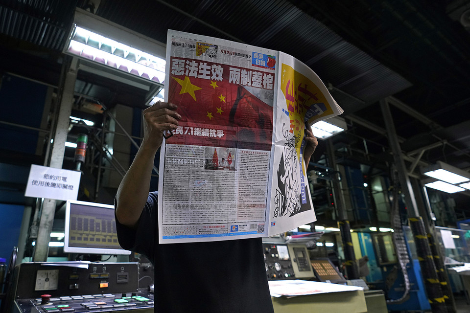 1일(현지시간) 홍콩의 한 신문 인쇄소에서 이곳 직원이 "악법 발효, 일국양제 붕괴"라고 1면을 장식한 빈과일보 판본을 확인하고 있다. 홍콩=AP