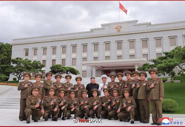 노동당 본부청사 앞에서 백두산 기념 권총을 들고 단체 사진을 찍고 있다. 사진=NEW DPRK