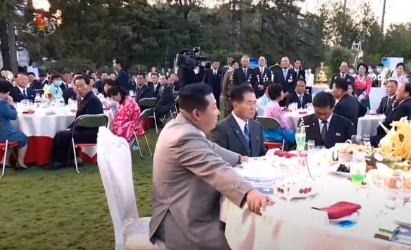 김정은 총비서 뒷편 테이블에 앉은 사람이 마스크를 쓰고 있다. 사진=조선중앙TV