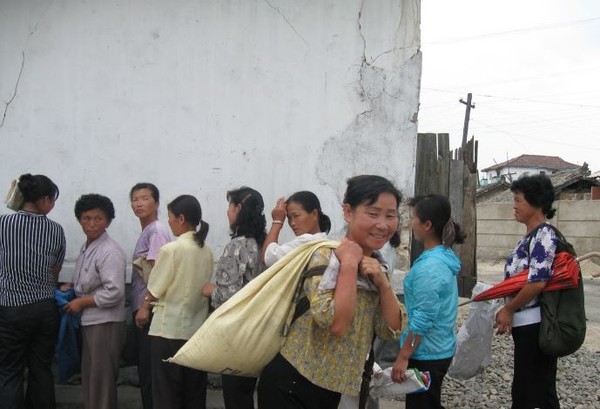북한의 한 아주머니가 쌀을 배급받아 집으로 향하고 있다. 사진=시사주간 DB