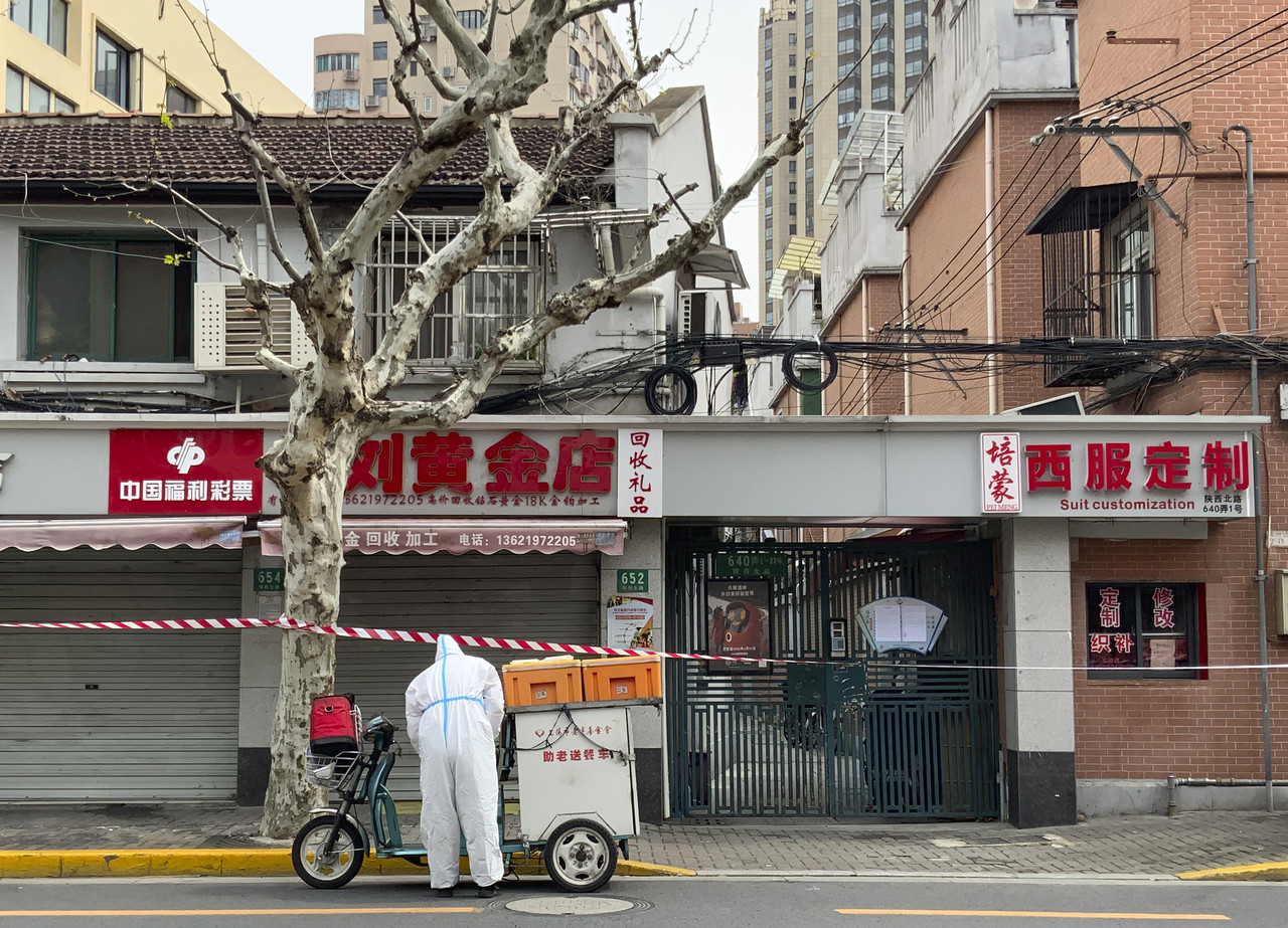 지난 1일 상하이 서부 징안 지구에서 보호복을 입은 한 배달원이 노인들을 위한 음식 배달을 준비하고 있다. 중국 정부는 오미크론의 확산으로 상하이 서쪽인 '푸시' 지역을 전면 봉쇄했다. 상하이=AP