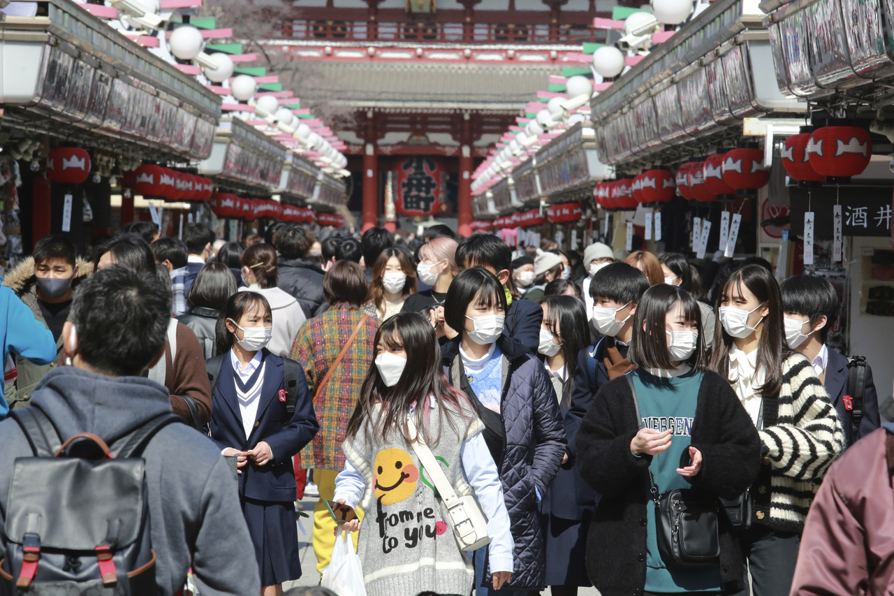 일본 도쿄 아사쿠사구에 있는 쇼핑 아케이드 거리가 코로나19 예방을 위해 마스크를 착용한 손님들로 북적이고 있다. 도쿄=AP