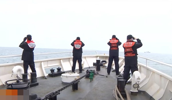 해양경찰이 2020년 9월 사고 해역에서 망원경으로 바다를 살피고 있다. 사진=시사주간 DB