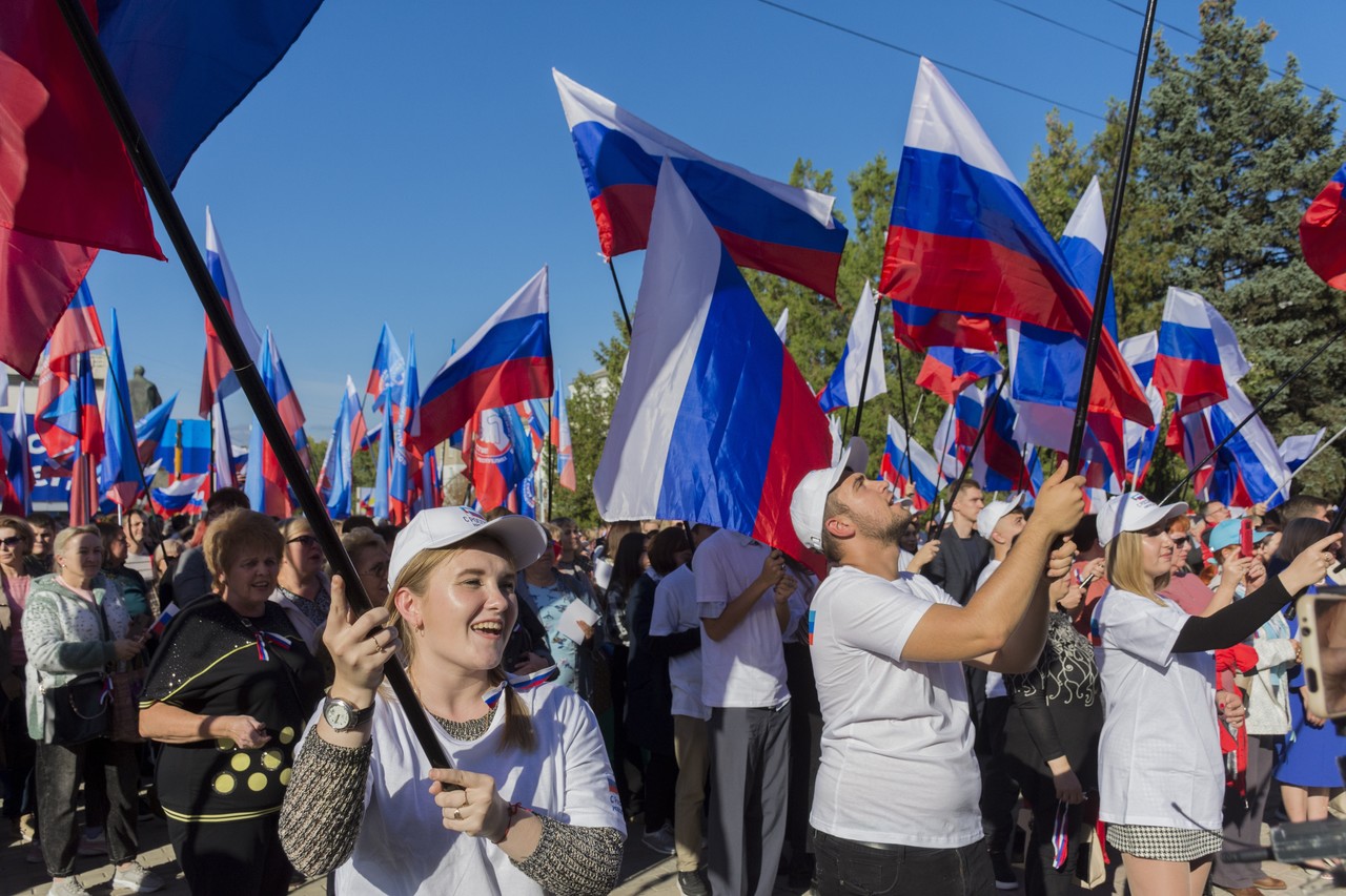 지난달 30일(현지시간) 우크라이나 동부 루한스크인민공화국(LPR) 루한스크에서 열린 러시아와의 병합 축하 행사에 모인 주민들이 러시아 국기를 흔들고 있다. 루한스크=AP
