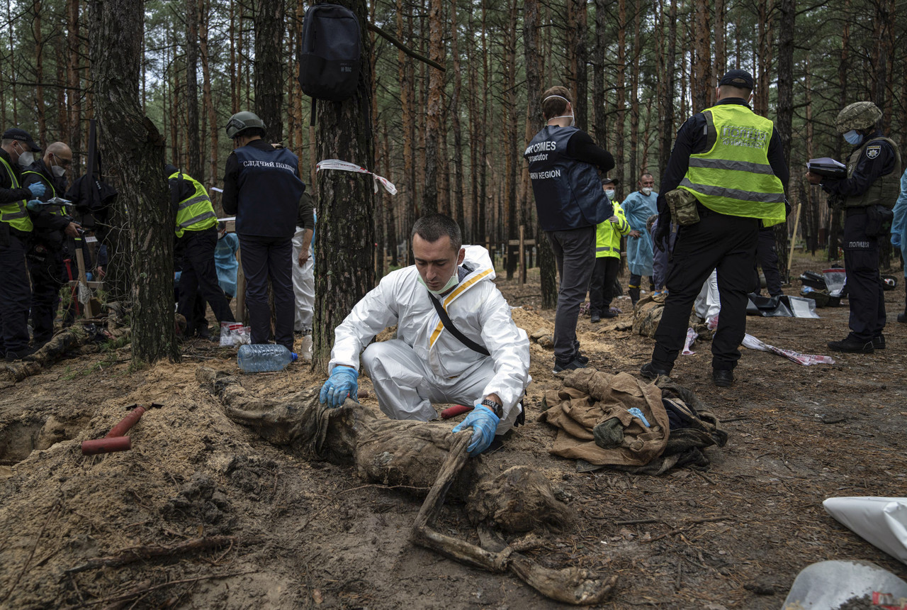 지난달 16일(현지시간) 우크라이나 하르키우주 이지움의 시신 440구가 묻힌 집단 매장지에서 조사관들이 시신 발굴 및 조사 작업을 벌이고 있다. 이지움(우크라이나)=AP