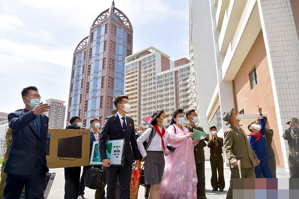 '살림집리용 허가증'을 들고 새 아파트로 향하는 북한 주민들. 사진=조선중앙TV