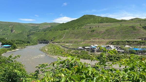 '압록강' 표지석 뒤로 압록강 건너 북한군 초소와 부대가 보인다. 사진=소식통