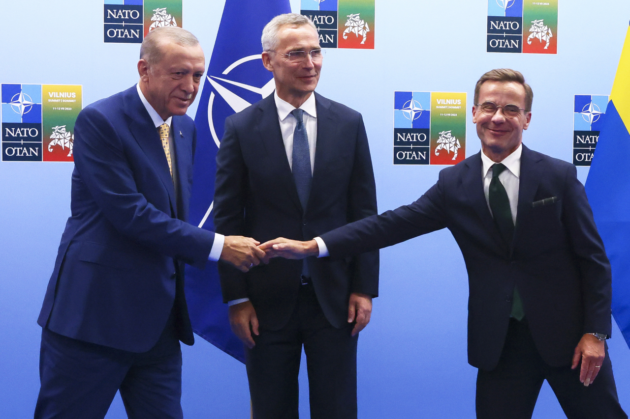 레제프 타이이프 에르도안(왼쪽) 튀르키예 대통령이 2023년 7월 10일(현지시각) 리투아니아 빌뉴스에서 열리는 북대서양조약기구(NATO·나토) 정상회의를 하루 앞두고 울프 크리스테르손 스웨덴 총리와 회담 전 악수하고 있다. 가운데는 옌스 스톨텐베르그 나토 사무총장. 빌뉴스=AP