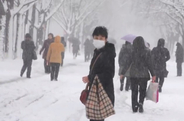 눈 내리는 21일 한 평양 주민이 뒤를 돌아보고 있다. 사진=조선중앙통신