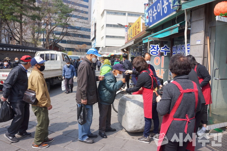 급식소 자원봉사자들이 어르신들에게 주먹밥을 나누어주고 있다. 사진=임동현 기자