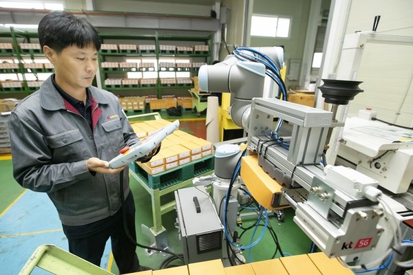 충북 제천에 있는 박원 공장에서 생산직 근로자가 KT 5G 스마트팩토리 코봇과 함께 작업하고 있는 모습.  사진 출처 = KT