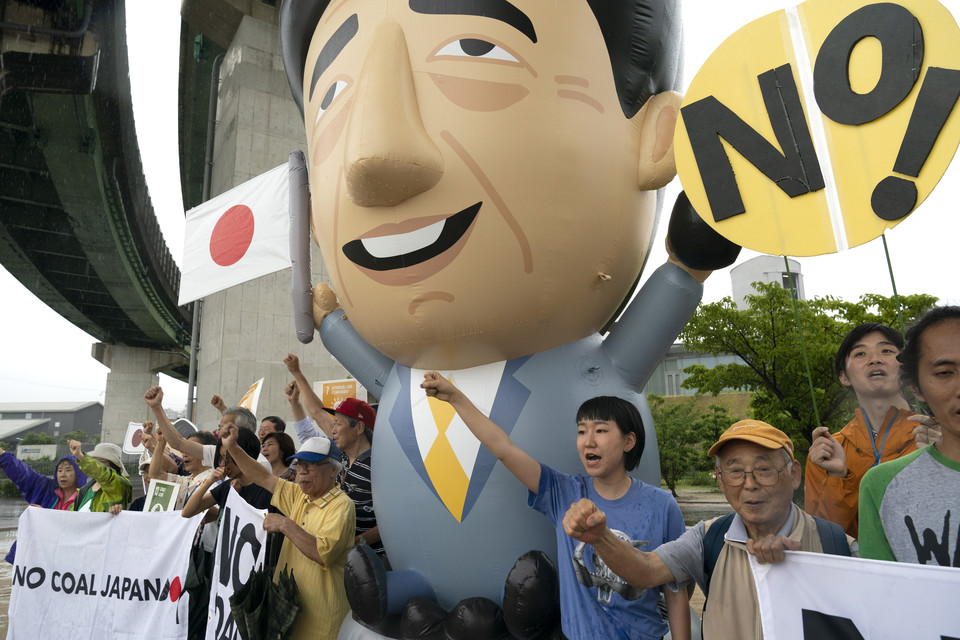 지난해 6월 28일 오사카에서 열리는 주요 20개국(G20) 정상회의를 앞두고 27일 일본 고베에서 환경운동가들과 지역주민들이 석탄 화력발전소 앞에 모여 아베 신조 일본 총리 풍선 인형을 세우고 구호를 외치고 있다. 고베=AP
