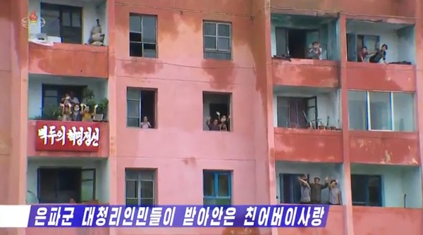 아파트 주민들도 환영의 박수를 치고 있다. 사진=조선중앙TV