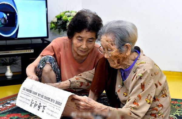 103세 할머니가 딸과 노동신문을 보고 있다. 사진=