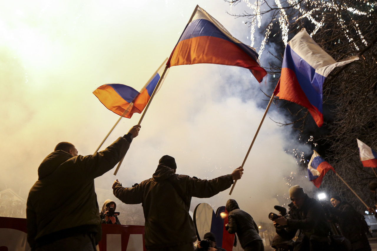 21일(현지시간) 우크라이나 동부 친 러시아 반군 지역인 도네츠크 중심가에서 사람들이 러시아 국기를 흔들며 독립을 축하하고 있다. 블라디미르 푸틴 러시아 대통령은 돈바스 지역(도네츠크, 루한스크)의 독립을 승인하면서 이들 지역에 러시아 군대를 파견해 러시아 정부가 '평화유지 활동'을 수행할 것이라고 밝혔다. 도네츠크=AP