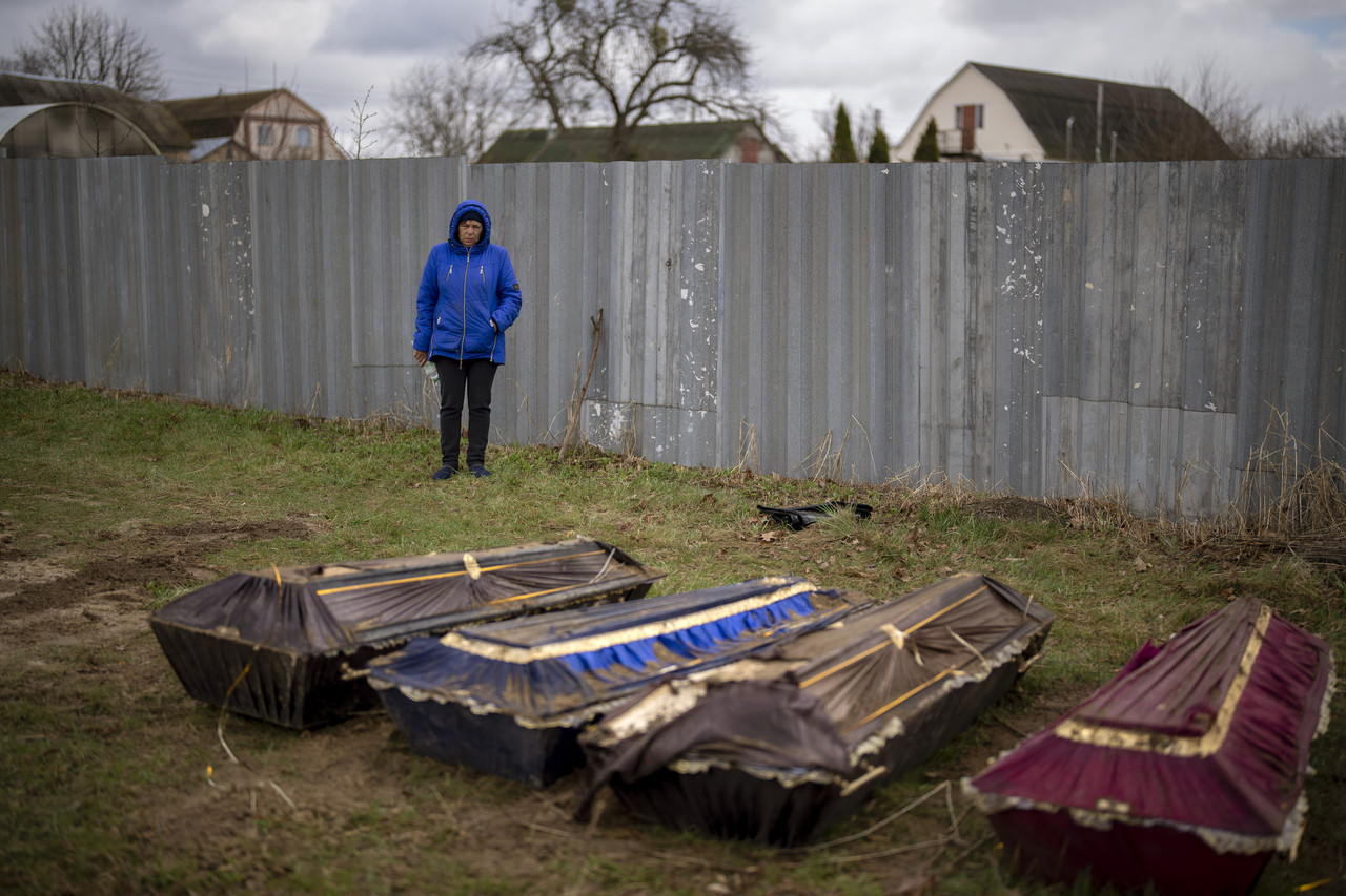 지난 17일(현지시간) 우크라이나 미쿨리치에서 한 여성이 집단 묘지에서 발굴한 남편의 시신이 담긴 관 옆에 서 있다. 러시아군이 사라진 지 2주째에 접어들면서 자원봉사자들은 신원 확인 작업을 위해 집단 묘지에 묻혔던 시신들을 발굴해 시신 안치소로 옮기고 있다. 미쿨리치=AP