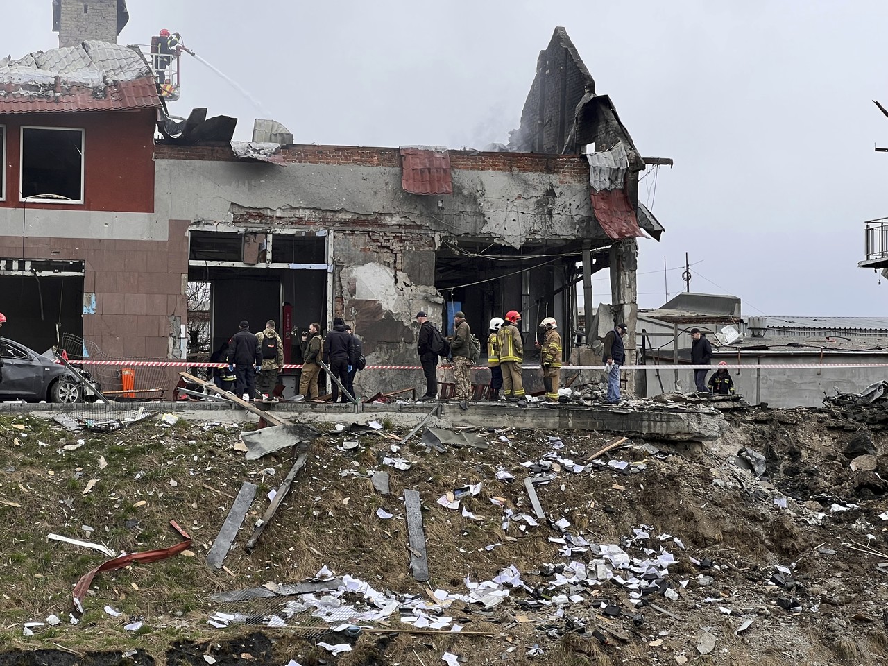 18일(현지시간) 우크라이나 서부 르비우에 있는 타이어 상점이 러시아군 미사일 공습을 받은 후 구조대원들이 잔해를 치우고 있다. 우크라이나 당국자는 르비우에 러시아의 소행으로 추정되는 미사일 폭격으로 최소 7명이 숨지고 11명이 다쳤다고 밝혔다. 르비우=AP