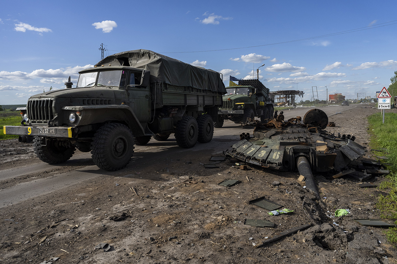 지난 13일(현지시간) 우크라이나 하루키우 북부에서 우크라이나군 차량이 러시아군 전차 잔해를 지나고 있다. 하르키우=AP