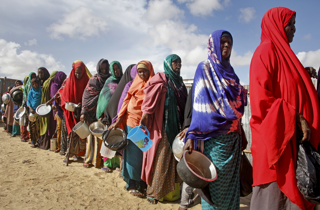 소말리아 수도 모가디슈 외곽 데이닐 인근 난민촌에 모여든 가뭄 피해 여성들이 자원봉사자들이 나눠주는 음식을 받기 위해 줄지어 서 있다. 모가디슈=AP