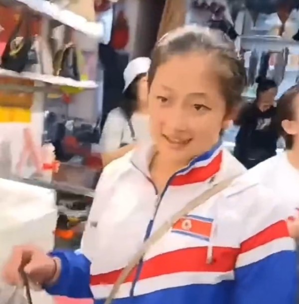 항저우 아시안게임에서 금메달을 딴 북한 안창옥 선수가 단둥 신류시장에서 가방을 구입하고 있다. 사진=소식통